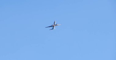 Bulutsuz mavi gökyüzünde havalandıktan sonra yüksek irtifaya yükselen yolcu uçağı.