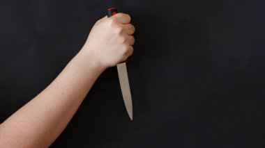 Siyah arka planda keskin bir bıçak tutan adamın eli. Suç mahalli, cinayet, seri katil konsepti arkaplan resmi.