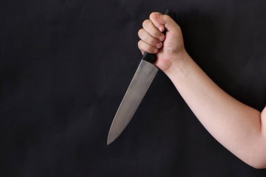 Siyah arka planda mutfak bıçağı tutan bir adamın eli. Suç mahalli, cinayet, seri katil konsepti arkaplan resmi.
