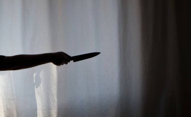 Karanlıkta elinde bıçak tutan birinin silueti. Suç mahalli, cadılar bayramı, korku, cinayet, seri katil konsepti.