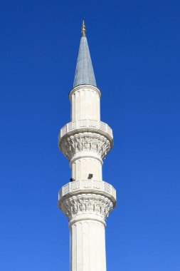 Beyaz renkli cami minaresi mavi gökyüzü arka planında Türk mimarisi ile yapıldı.