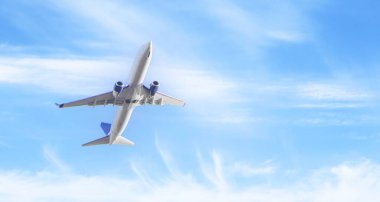 Mavi gökyüzünde havalandıktan sonra yükselen beyaz yolcu uçağı.