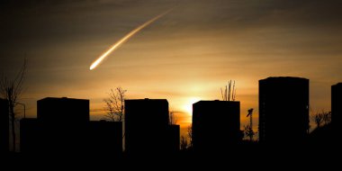 Şehir silueti ve meteor, asteroid ya da gök cisminin fotoğrafı. Yanan kuyruklu yıldız ve günbatımı gökyüzü.