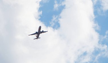 Bir yolcu uçağı bulutlu bir gökyüzünde dönüş manevrası yapıyor..