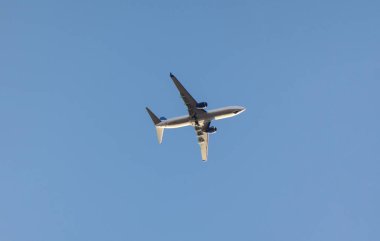 Bulutsuz havada iniş takımlarıyla uçan yolcu uçağının yan görüntüsü. Hava taşımacılığı, tatil ve seyahat konsepti fotoğrafı.