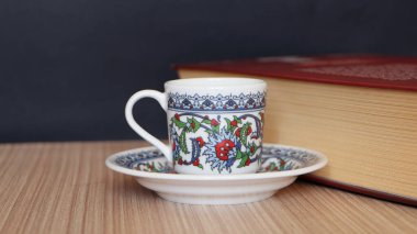 Kalın kitap ve Türk kahve fincanı masanın üstünde.. 