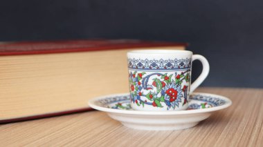 Masada kalın bir kitap ve Türk kahve fincanı var. Kahve molası. Türk kahvesi arkaplan fotoğrafı.