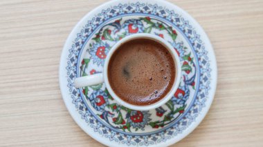 Türk kahvesi, köpüklü Türk kahvesi. Osmanlı motifleri ve desenleriyle süslenmiş seramik Türk kahve fincanının üst görüntüsü..
