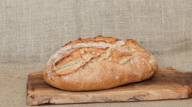 Yumuşak, kabuklu taze ekmek fotoğrafı. Tahta kesme tahtasının üzerinde taze pişmiş ekmek..