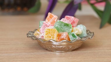 Türk Lokumu (Türk Lokumu). Ahşap masadaki küçük gümüş şeker kasesinde lezzetli ve renkli Türk tatları.