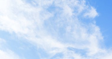 Açık mavi gökyüzünde süzülen ince beyaz bulutlar. Huzurlu bir gökyüzü. Bulutlu, temiz gökyüzü arkaplanı.