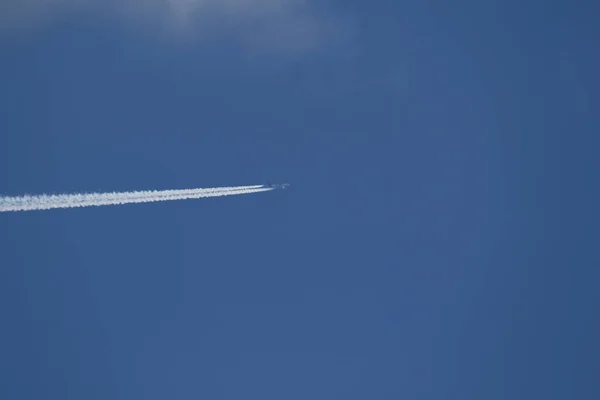 A plane and vapor trails in the sky