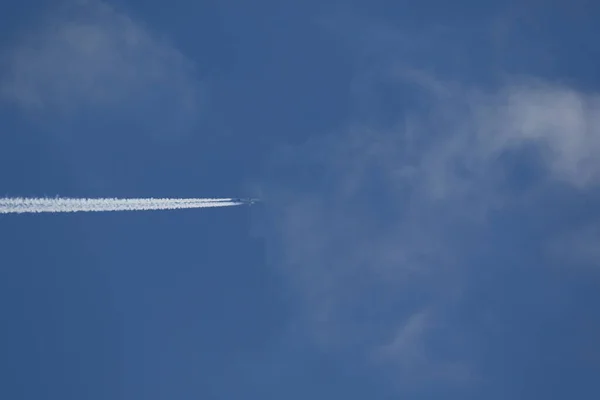 A plane and vapor trails in the sky