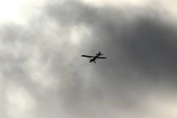 Gökyüzünde Kara Bulutlara Karşı Uçan Küçük Bir Uçak — Stok fotoğraf