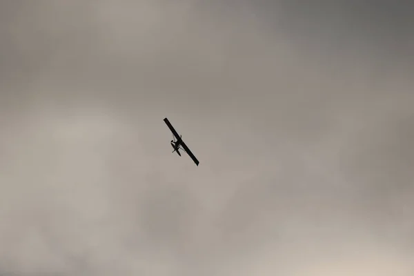 Μικρό Αεροπλάνο Που Πετάει Στον Ουρανό Ενάντια Στα Μαύρα Σύννεφα — Φωτογραφία Αρχείου