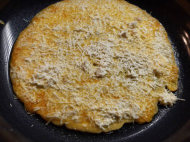 Siyah demir bir tavada peynirli omlet.