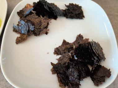 Beyaz tabakta servis edilen kurutulmuş yosun.