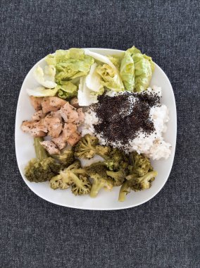 Beyaz tabakta servis edilen pilav ve brokoli ile ev yapımı ızgara tavuk.