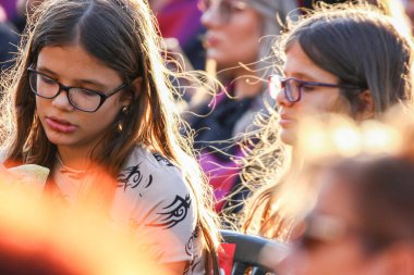 TIMISOARA, ROMANIA - 12 Temmuz 2022: Mezuniyetini arkadaşlarıyla kutlarken sandviç yiyen genç bir kıza yakından bakın