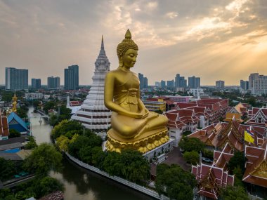 Gün batımında Wat Pak Nam Phasi Charoen Tapınağı 'nda Büyük Buda heykelinin (Phra Buddha Dhammakaya Thepmongkhon) yanından bir tekne geçiyordu..