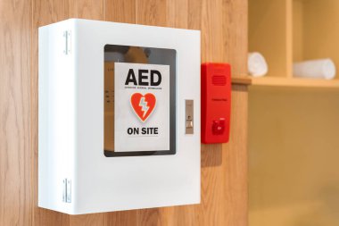 Hayat kurtaran bir defibrilatörün genel görünümü. Taşınabilir dış defibrilatör (AED) havaalanındaki umumi tuvaletin duvarına monte edildi