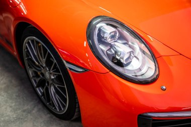 Modern kırmızı araba far ve güneş ışınlarının yakın görüntüsü.