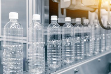 İçme suyu üretim sürecinin yüksek teknolojisi. Taşıma bandındaki boş içme suyu şişelerini doldurmak için.. 