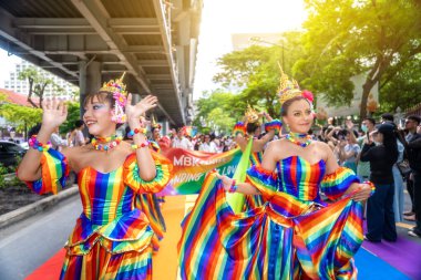 Bangkok, Tayland - 1 Haziran 2025: LGBTQIA + Gökkuşağı Tayland kostümlü lezbiyen çift bir geçit töreninde dans ediyor.