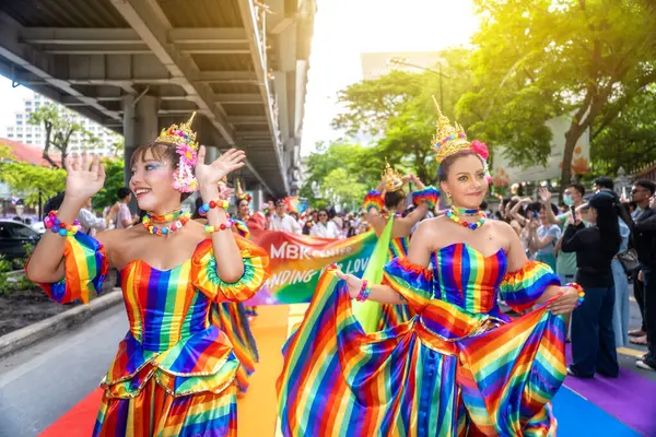 Bangkok, Tayland - 1 Haziran 2025: LGBTQIA + Gökkuşağı Tayland kostümlü lezbiyen çift bir geçit töreninde dans ediyor.
