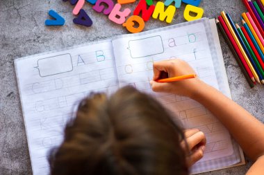 English alphabet made of square wooden tiles with the English alphabet scattered on hand. The concept of thinking development, grammar