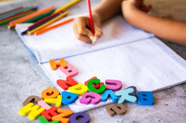 English alphabet made of square wooden tiles with the English alphabet scattered on hand. The concept of thinking development, grammar