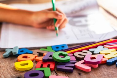 English alphabet made of square wooden tiles with the English alphabet scattered on hand. The concept of thinking development, grammar