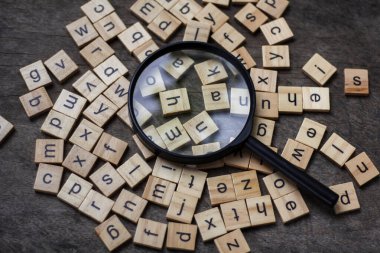 English alphabet made of square wooden tiles with the English alphabet scattered on table background. The concept of thinking development, grammar