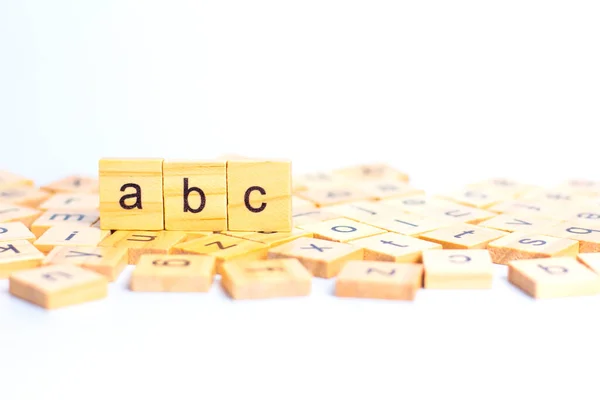 English alphabet made of square wooden tiles with the English alphabet scattered on white background.