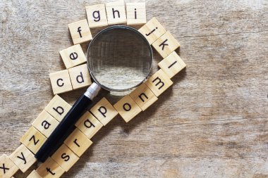 Ahşap zemin üzerine dağılmış İngiliz alfabesi ile kare ahşap fayanslardan yapılmış İngiliz alfabesi. Düşünce geliştirme konsepti, dil bilgisi.