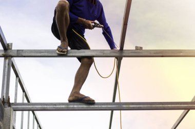Home roof frame welder. concept working at unsafe height. not wear protective equipment to work.