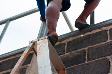 Home roof frame welder. concept working at unsafe height. not wear protective equipment to work.