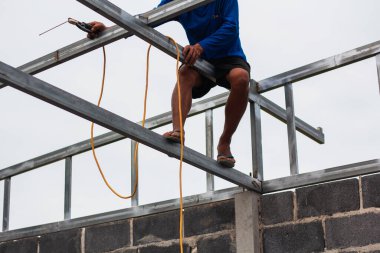 Home roof frame welder. concept working at unsafe height. not wear protective equipment to work.
