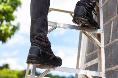Wear safety shoes to ensure safety at work. construction workers wear safety shoes. concept construction workers work on the stairs