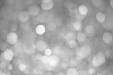 White glitter vintage lights background.  White bokeh shiny on dark background.