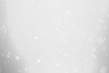 White glitter vintage lights background.  White bokeh shiny on dark background.