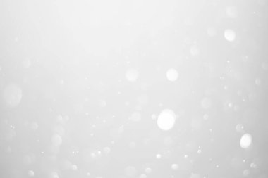 White glitter vintage lights background.  White bokeh shiny on dark background.