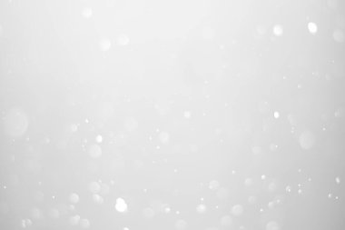 White glitter vintage lights background.  White bokeh shiny on dark background.