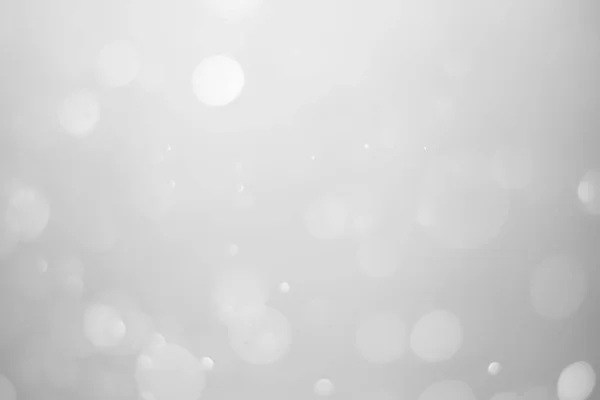 White glitter vintage lights background.  White bokeh shiny on dark background.