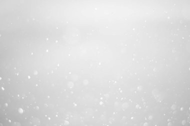 White glitter vintage lights background.  White bokeh shiny on dark background.