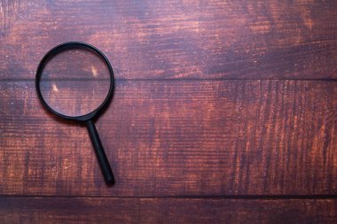 Magnifier placed on a wooden table, there is free space.