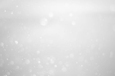 White glitter vintage lights background.  White bokeh shiny on dark background.
