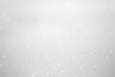 White glitter vintage lights background.  White bokeh shiny on dark background.