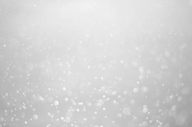 White glitter vintage lights background.  White bokeh shiny on dark background.