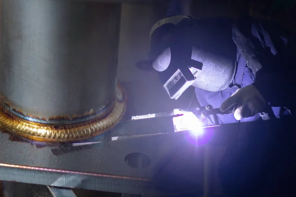 İnşaat alanı metal kaynakçısı. İnşaatçılar iş yerinde güvenlik için yangın geçirmez eldiven giyerler. Kaynakçılar bir fabrikada kaynakçılık yapıyor..